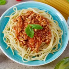 Pyszne spaghetti bolognese na talerzu, idealne na obiad. Dowiedz się, jak zrobić spaghetti krok po kroku!
