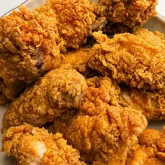 Talerz pełen chrupiącego kurczaka w panierce, przypominającego smak oryginalnego przepisu KFC.