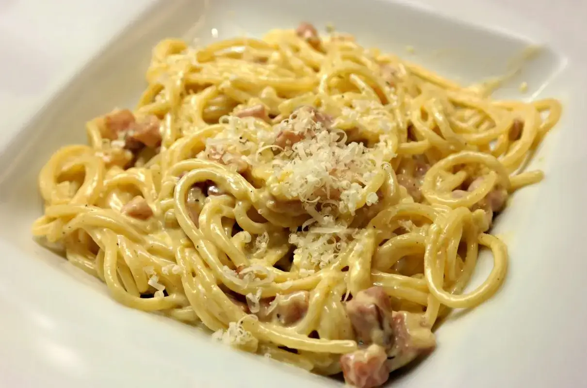 Spaghetti carbonara - przepis oryginalny ze śmietaną. Kremowy sos, kawałki guanciale i parmezan na idealnie ugotowanym makaronie.